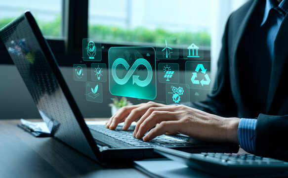 Businessman working on laptop with sustainability, featuring infinity loop symbol for circular economy, renewable energy, green technology, eco-friendly business strategy, and environmental innovation
