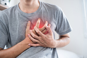 Asian Man holding His Chest with Both Hands, Showing Possible Symptoms of Heart Disease, Angina and heart attack of Cardiovascular Risk
