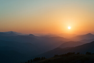 Fototapeta premium Layers of Mountains in a Colorful Sunrise Mist