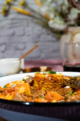Delicious beef stew called carbonada with corn, potatoes, and carrots simmering in rich tomato sauce