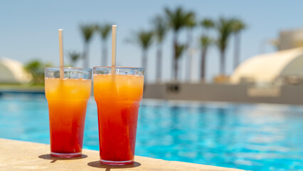 Two fresh cocktails on the edge of the pool on vacation