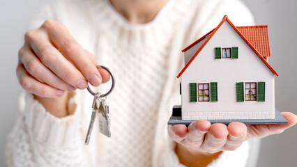 Realtor holding house keys and house model