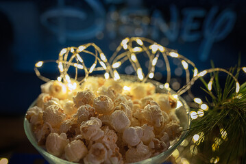 Bowl of freshly popped popcorn against a festive backdrop with soft lights in the evening