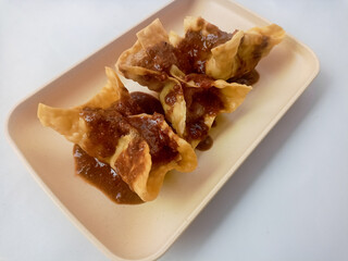 Batagor isolated on white Background, made from fish or chicken dumpling, tofu, tapioca flour served with peanut sauce. Indonesian food