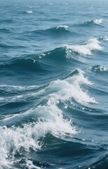 A close-up view of the ocean water with natural waves forming and crashing. The sea is deep blue with white foam, reflecting light on a clear day. 