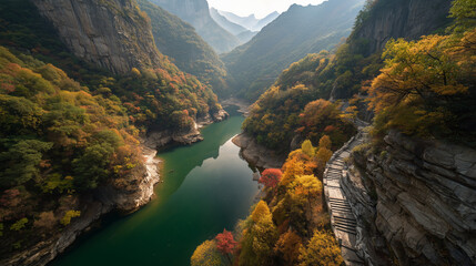 A tranquil river canyon during autumn, crimson and amber trees dotting steep hillsides, sunlight piercing through clouds to reflect off emerald water, stone pathway carved into cliff face.