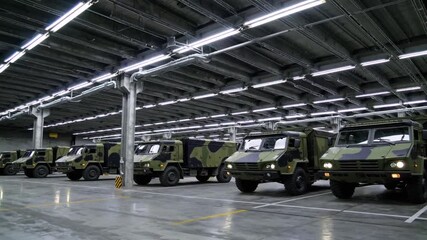 Military transport vehicles in a well-lit storage facility ready for deployment in operational scenarios