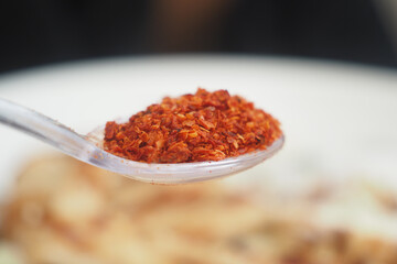 Red chili flakes enhance meals at a dining table