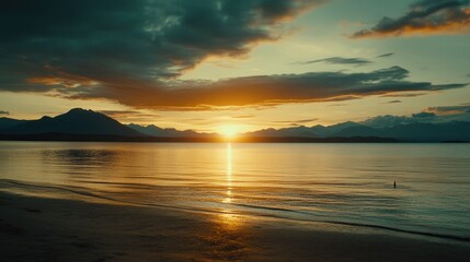 Obraz premium Golden sunset over a tranquil coastal scene.