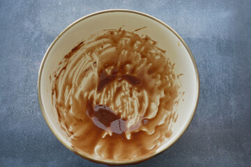 Empty bowl shows remnants of chocolate mixture after baking