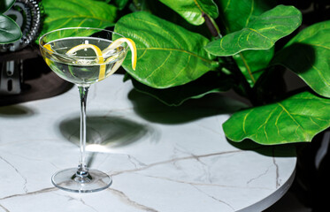 Savor the rich flavors of a dukes martini cocktail garnished with lemon peel, on a marble table