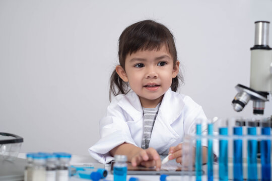 A young girl in a lab coat engages with scientific equipment, showcasing curiosity and a budding interest in science.