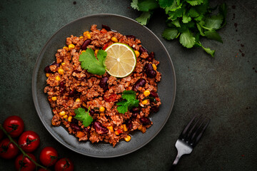 Mexican Chili dish with minced beef, beans, paprika, corn, cilantro, jalapeno pepper in tomato sauce, top view