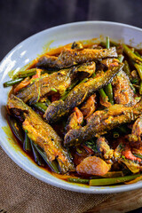 Traditional Bengali-style tangra fish curry cooked with onion flower stems (pyanjkoli) – tangra macher jhol with pyanjkoli, authentic Bengali fish dish, homestyle Indian fish curry, rustic comfort foo