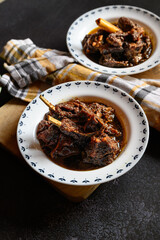Traditional Bengali-style mutton kosha served in a small white bowl – spicy Indian goat curry, authentic Bengali kosha mangsho, slow-cooked meat dish, homestyle mutton curry, rustic overhead view
