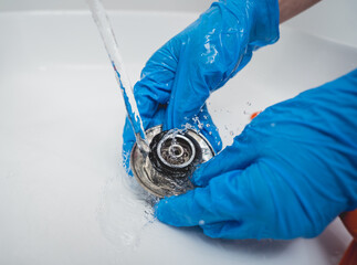 Young housewife diligently scrubs and cleans the sink in bathroom