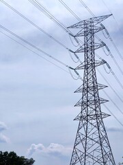 Standing tall against the backdrop of a clear blue sky, this power line tower plays a crucial role in our electrical supply system.