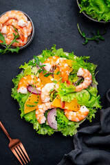 Gourmet shrimp salad with juicy orange, green lettuce, onion with olive oil and citrus juice...