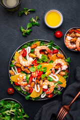 seafood salad with shrimp, mussels, squid, oranges, tomatoes, green lettuce and olemon dressing, top view