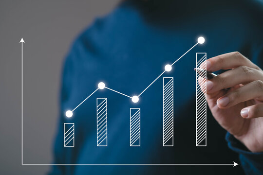 A person analyzing a growth chart with upward trends, signifying progress and success in data or business metrics. - Powered by Adobe