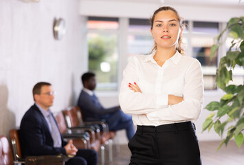 Young business woman in business clothes posing in office reception..