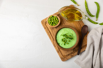 Green pea soup on a wooden table. Fresh pea soup bowl. Delicious healthy cream soup in a bowl with green peas and croutons. Healthy vegan puree. Copy space. Space for text.