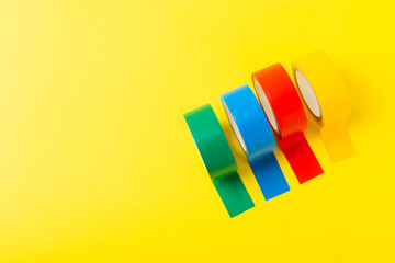 Insulating tape on a bright colored background. Set of different colors insulating tape. Reel...
