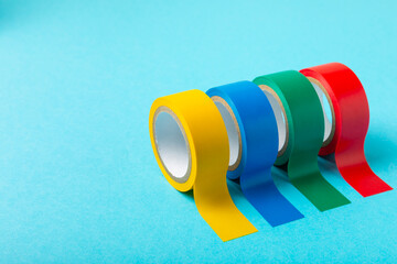 Insulating tape on a bright colored background. Set of different colors insulating tape. Reel...