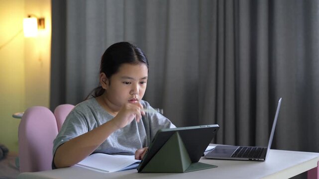 asian child student write learning on computer tablet screen by touch pen or kid girl fun studying writing art drawing on study online class by laptop notebook or young person learn from home school