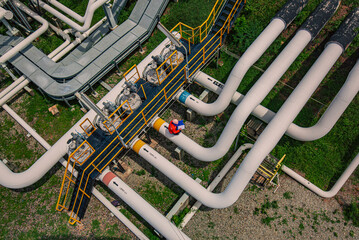 Male worker inspection at steel long pipes and pipe elbow in station oil factory during refinery...