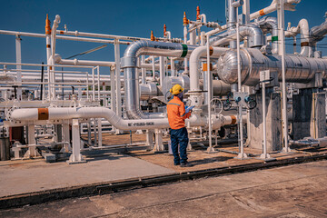 Male worker inspection at steel long pipes and pipe elbow in station oil factory during refinery...