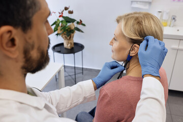 Specialist fine-tunes a hearing aid for a client, ensuring a perfect fit and optimal sound quality....