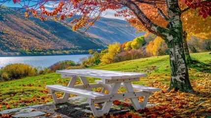 Autumnal lakeside picnic area, complete with leaves and colorful mountains beyond