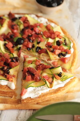 tarte à la courgette, stracciatella, tartare de tomates et olives noires