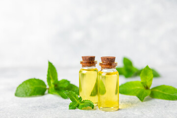 Essential oil mint on a wooden background. Peppermint essential oil with fresh mint leaves. A bottle of aromatherapy oil. Mint extract. The concept of natural cosmetics, spa care. copy space