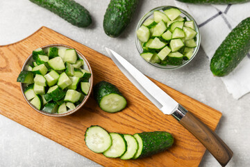 Cucumber on wooden background. Slice of cucumber on background. Fresh organic green cucumbers gherkin. Vegan. Salad ingredient. Farm vegetables. Cut vegetables with knife. Space for text. Copy space