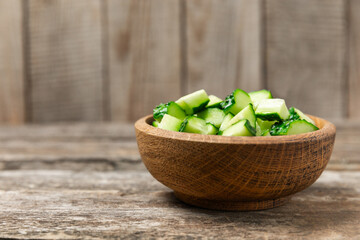 Cucumber on wooden background. Slice of cucumber on background. Fresh organic green cucumbers gherkin. Vegan. Salad ingredient. Farm vegetables. Cut vegetables with knife. Space for text. Copy space