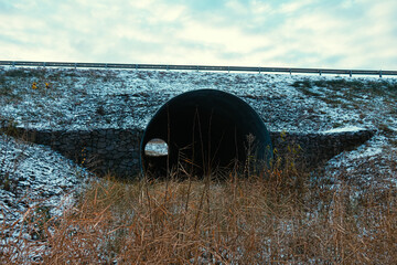 Big culvert under the highway. On the water in the pipe and shoots