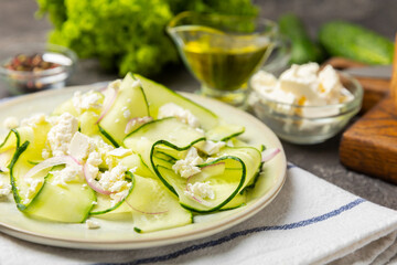 Cucumber salad on a wooden background.Homemade salad with fresh vegetables, cucumber, tomato, sweet...