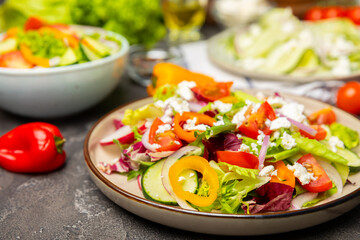 Cucumber salad on a wooden background.Homemade salad with fresh vegetables, cucumber, tomato, sweet...