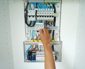 Electrician working checking a switchboard with fuses
