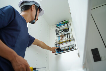 Electrician working checking a switchboard with fuses