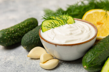 Cucumber sour cream tzatziki sauce on a wooden table.Tartar sauce. Traditional delicious appetizer....