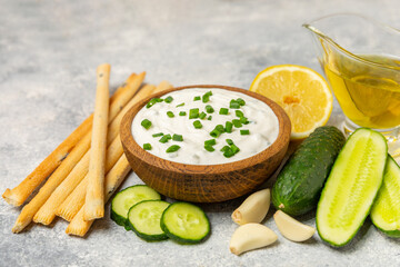 Cucumber sour cream tzatziki sauce on a wooden table.Tartar sauce. Traditional delicious appetizer....