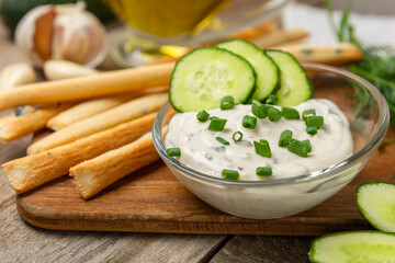 Cucumber sour cream tzatziki sauce on a wooden table.Tartar sauce. Traditional delicious appetizer. yogurt sauce. Tzatziki with ingredients cucumber, garlic,dill,lemon,mint. salad dressing.Copy space