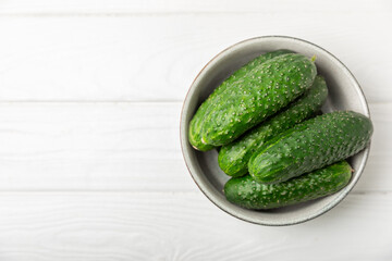 Cucumber on wooden background. Slice of cucumber on background. Fresh organic green cucumbers gherkin. Vegan. Salad ingredient. Farm vegetables. Cut vegetables with knife. Space for text. Copy space