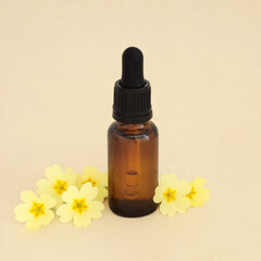 Primrose flower essence for herbal medicine, brown glass dropper bottle on hemp paper background. Stress, anxiety and insomnia reducing. Sedative and tranquilizer.