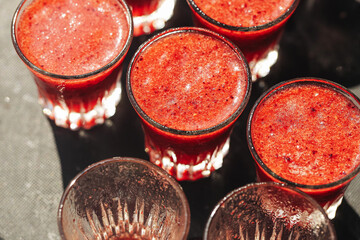 Fruity vodka shots in sunlight. Blended frozen fruits with alcohol. Summer party tray. Refreshing...
