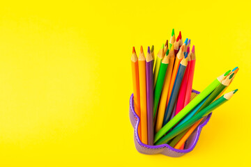 Colored pencils on a bright colored background. Equipment for coloring. Stationery for...