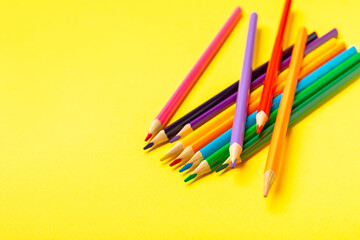 Colored pencils on a bright colored background. Equipment for coloring. Stationery for...